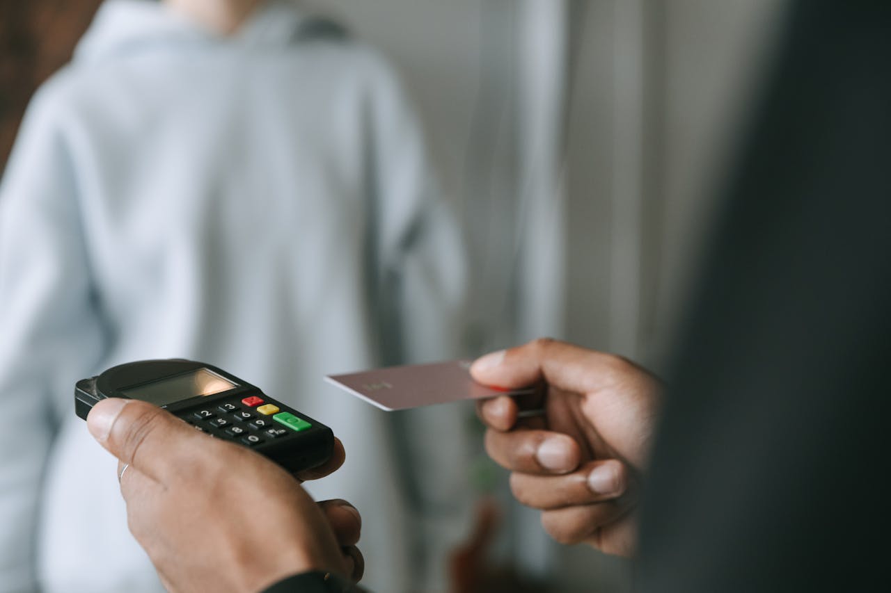 Close-up of a contactless payment with a card and POS terminal, showcasing secure electronic transactions.